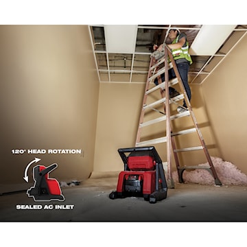 Ouvrier sur une échelle posant un plafond, éclairé par un projecteur de chantier rouge avec rotation à 120° et prise d’alimentation scellée.