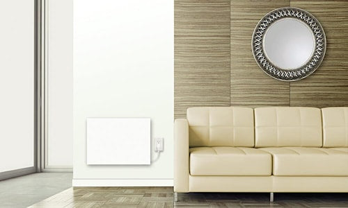 Chauffage électrique mural blanc installé dans un salon moderne, offrant une solution de chauffage discrète et élégante près d’un sofa beige.