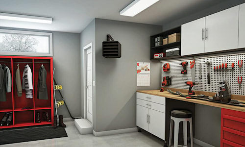 Atelier de garage moderne avec établi, outils suspendus, armoire rouge, chauffage mural noir et éclairage fluorescent au plafond.