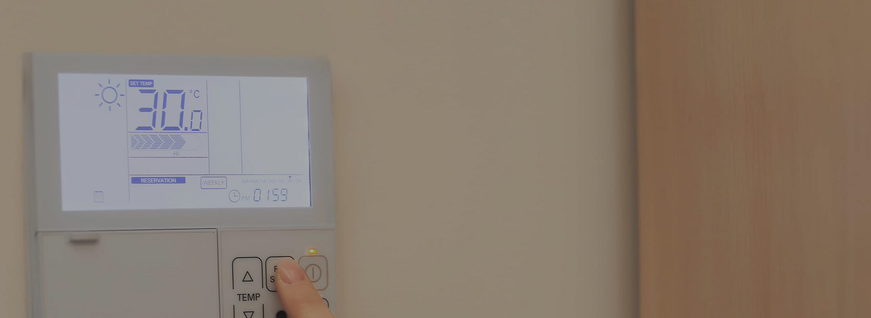 Technicien procédant à l'installation d'un thermostat mural résidentiel au Québec.