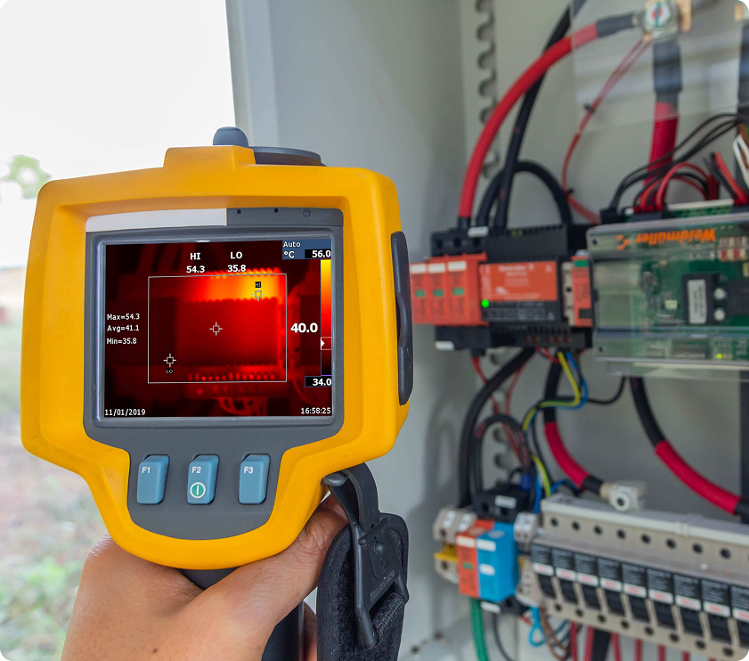Caméra d’inspection thermographique montrant un point chaud dans un panneau électrique, utilisée pour détecter des surchauffes et assurer la sécurité.
